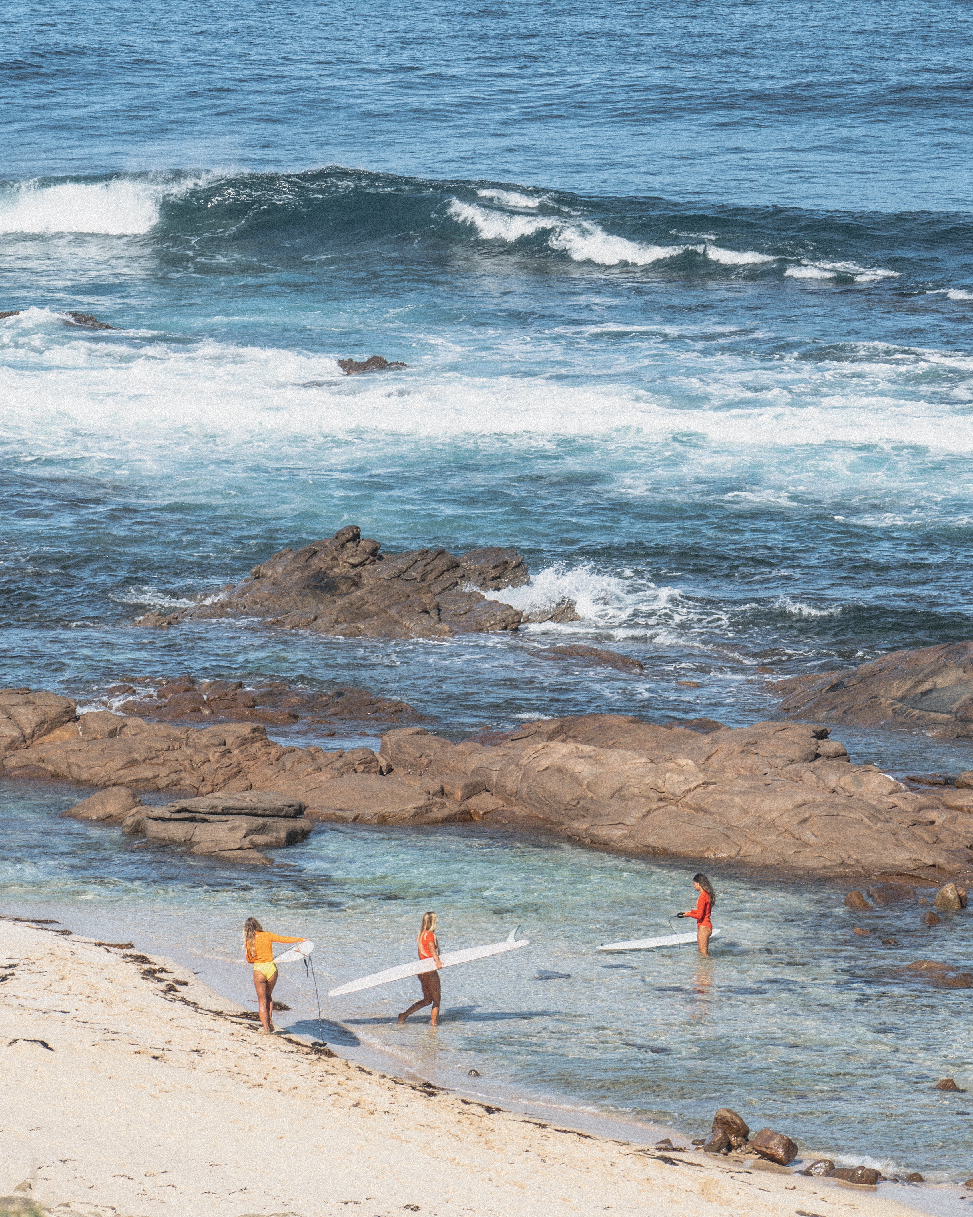 Women surfing in Nisi springsuits and surf separates